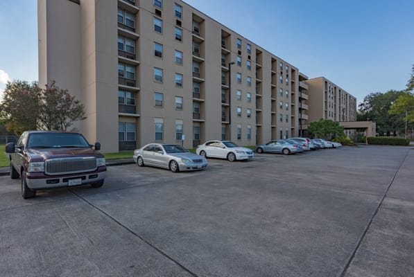 Parking lot in front of St. John Berchmans' Manor with several cars