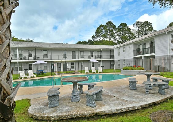 Swimming pool surrounded by seating at St. Theresa's Apartments.
