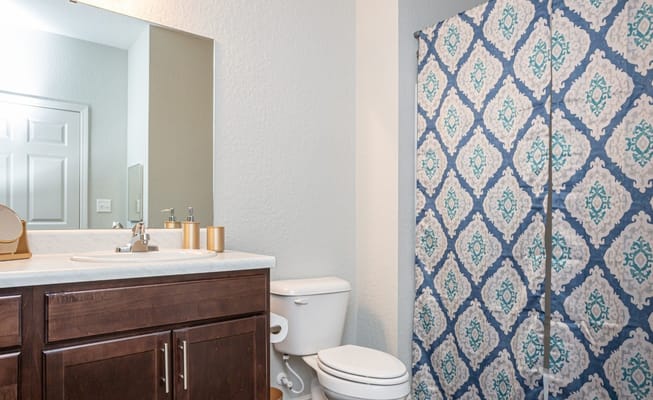 Modern bathroom with a decorative shower curtain and sink.