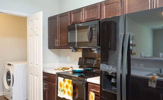 Well-equipped kitchen featuring dark cabinets and appliances