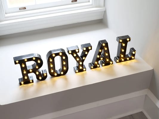 Light-up letters spelling 'ROYAL' on a windowsill