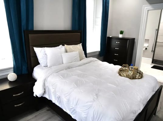 Cozy bedroom with a white bed and blue curtains