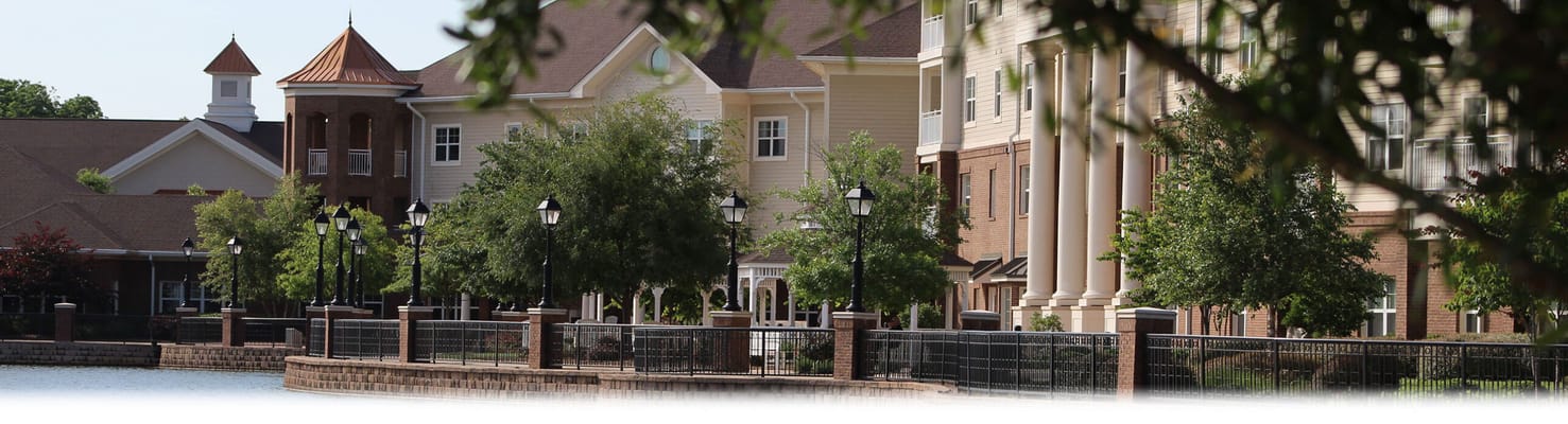 Exterior view of a senior living facility next to a lake