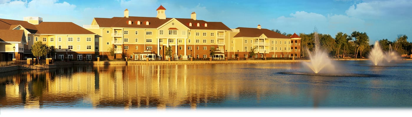 Exterior view of a senior living building by a lake