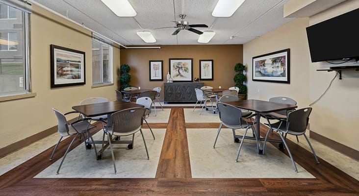 Bright common area with tables and chairs at Jordan Square Senior Apartments