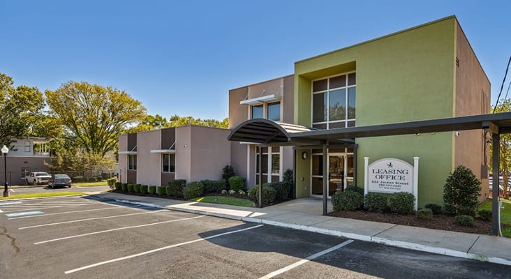 Leasing office at Jordan Square Senior Apartments with parking area
