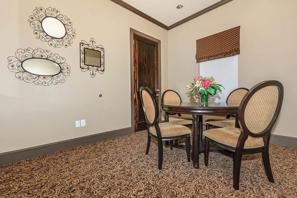 Cozy dining room with table and chairs, decorative mirrors on the wall.
