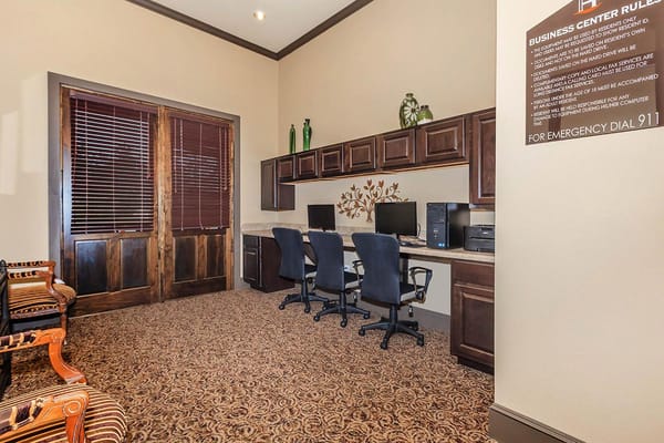 A cozy business center with computers and seating at The Havens of Lake Charles.