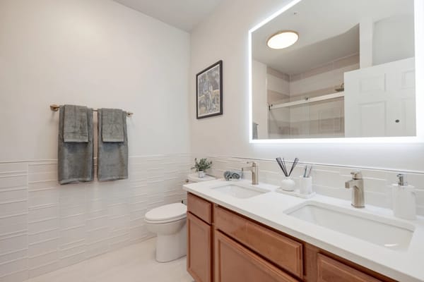 A modern bathroom with double sinks and a large mirror