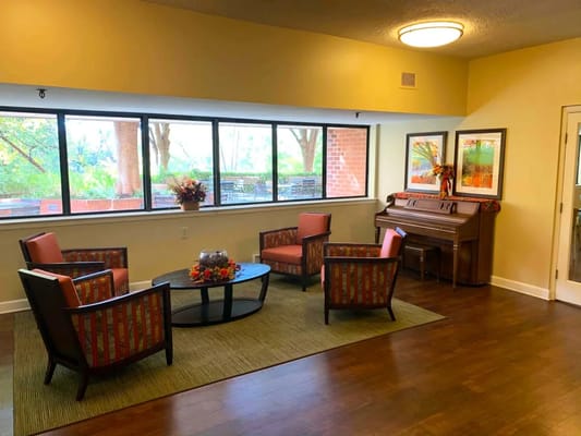 Bright common area with comfortable seating and a piano