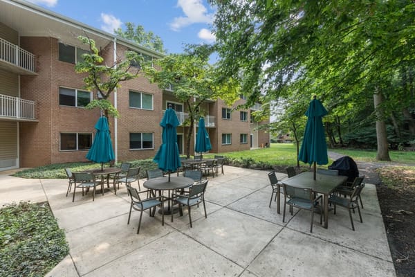 Outdoor seating area with tables and umbrellas at Hickory Ridge Place