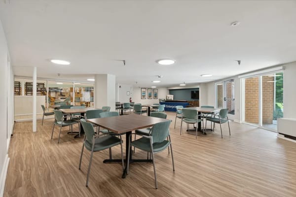 Spacious common area with tables and chairs at Hickory Ridge Place