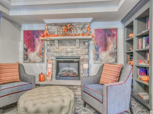 Cozy seating area featuring a stone fireplace and autumn decorations.