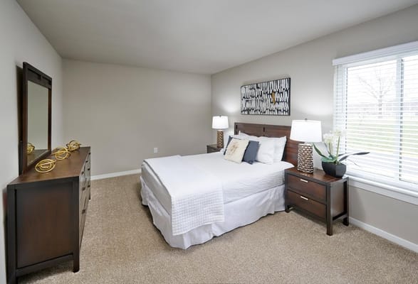 Bright and inviting bedroom with a bed, dresser, and window.