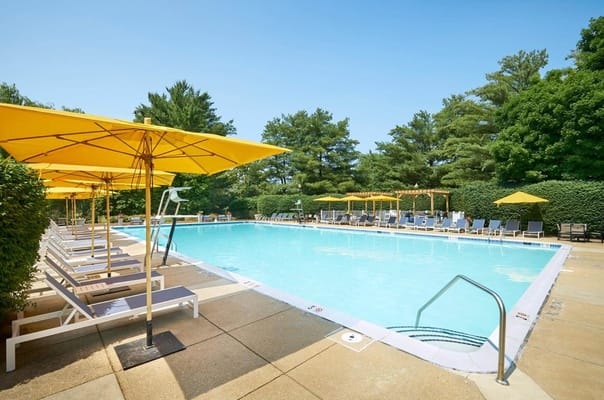 Outdoor swimming pool with yellow umbrellas and lounge chairs