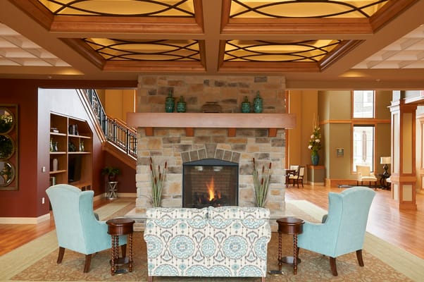 Cozy lobby seating area with a stone fireplace and decorative accents