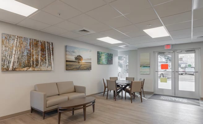 Cozy lounge area with seating and wall art in Sharpe Square Senior Apartments.