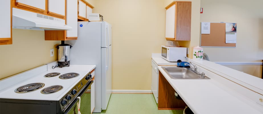 Bright kitchen with stove, refrigerator, and countertop