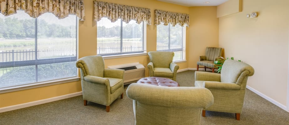 Cozy living area with green chairs and large windows