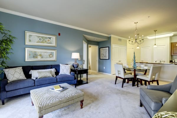 A well-furnished living room featuring a couch, a coffee table, and a dining area.