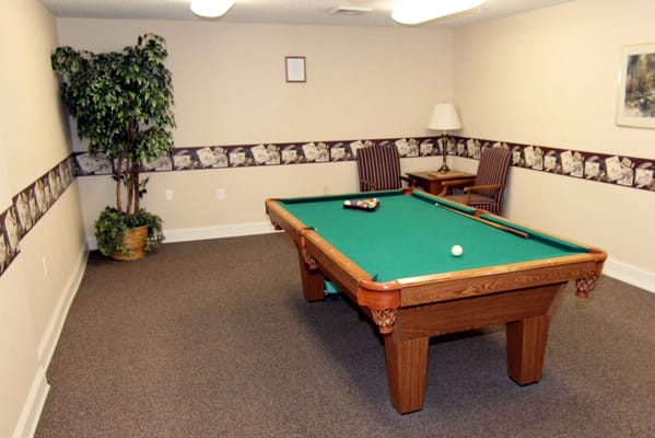 A pool table in a well-lit activity room