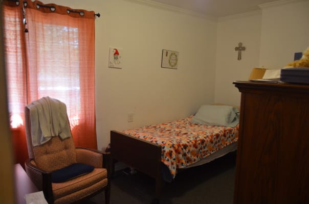A private resident room with a bed and chair