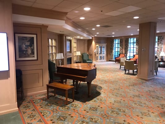 Bright common area with seating and a piano