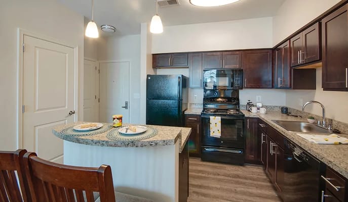 View of a modern kitchen with black appliances and granite countertops