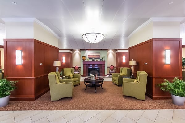 Cozy common area with green chairs and fireplace