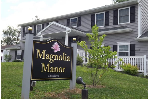 Exterior view of Magnolia Manor facility with sign