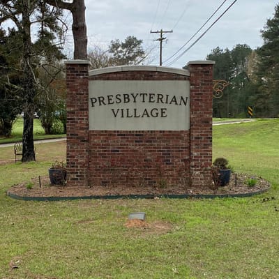 Sign for Presbyterian Village in a grassy area