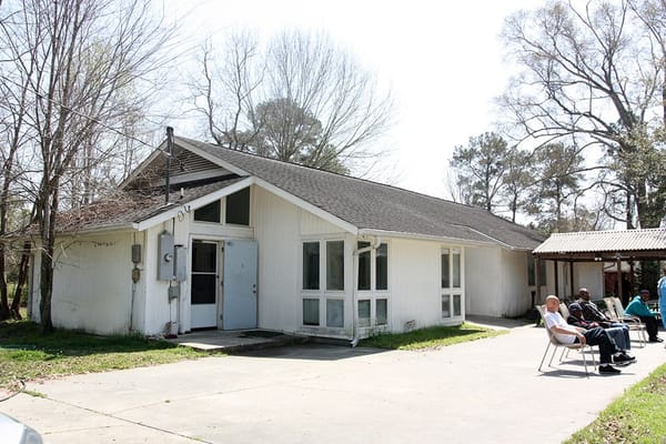 Exterior view of River Oaks Estate with residents enjoying the outdoors.