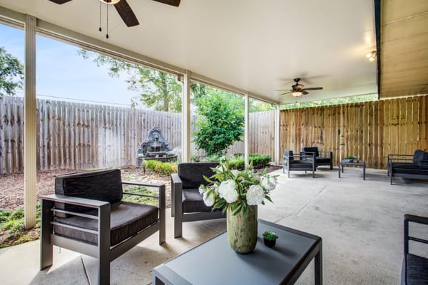 Covered outdoor seating area with plants and fountain
