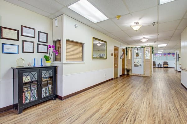 Interior hallway of a nursing facility with decor and signage