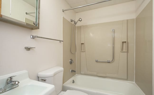 A spacious and accessible bathroom with a shower and bathtub.