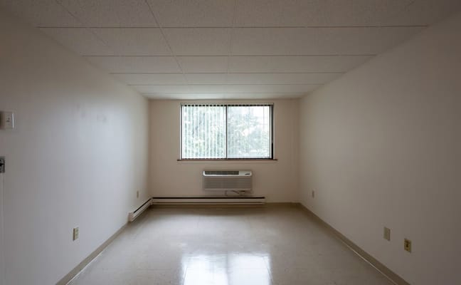 Empty interior room with a window and air conditioner
