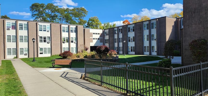 A well-maintained courtyard with green grass and flower beds at Hunter Place Apartments.