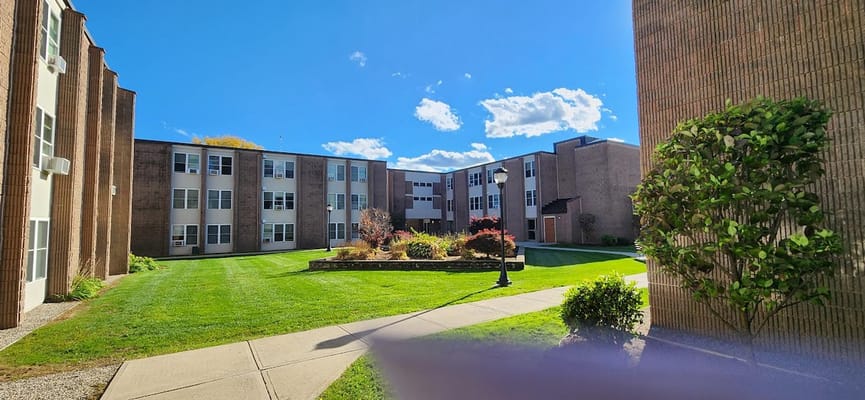 View of the courtyard with green grass and flowers at Hunter Place Apartments.