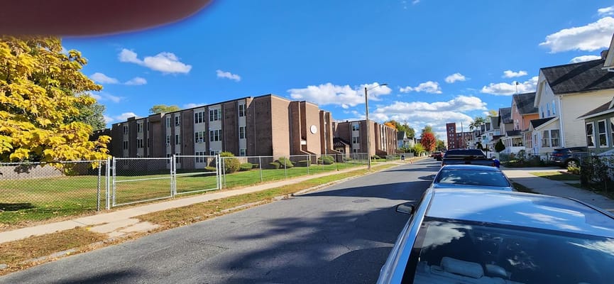 Street view showcasing the Hunter Place Apartments with a clear blue sky.