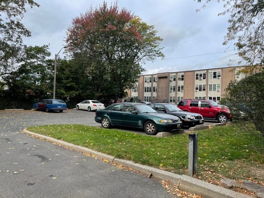 View of the parking lot at Hunter Place Apartments with several cars parked.