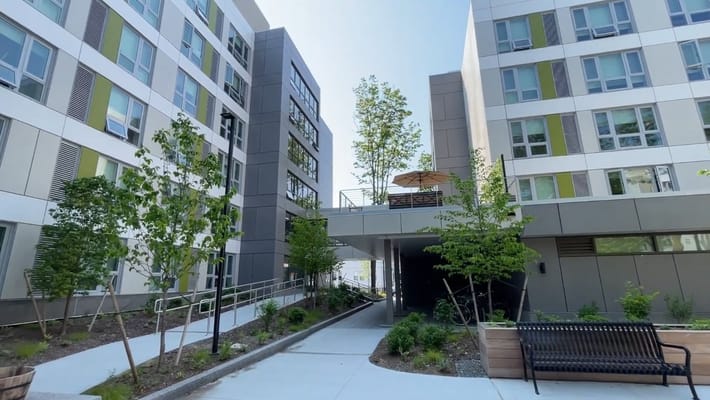 View of the courtyard surrounded by apartment buildings with greenery