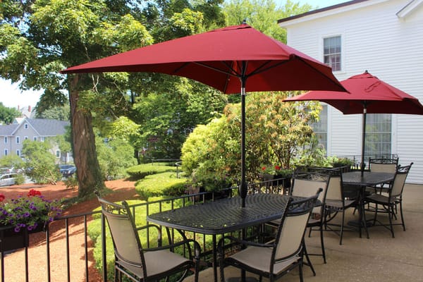 Outdoor dining area with red umbrellas and seating
