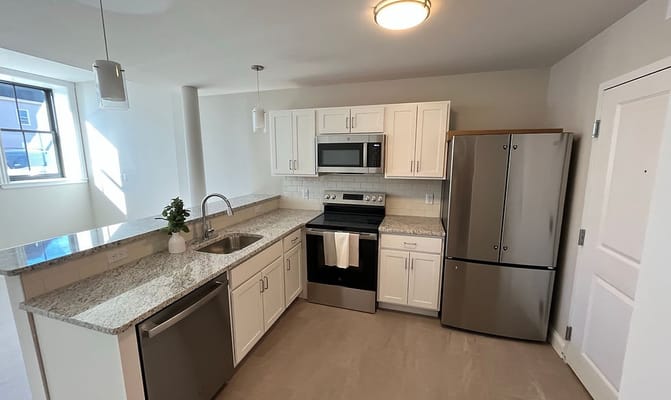 A modern kitchen with stainless steel appliances and granite countertops.