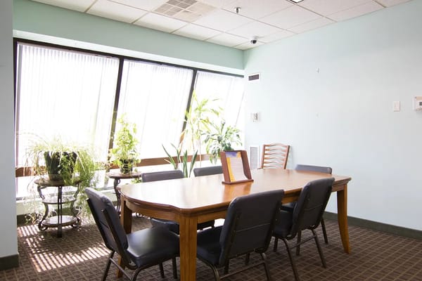 Bright, spacious common area with a large table and plants
