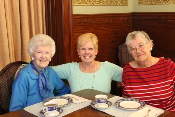 Three residents enjoying tea in the dining room