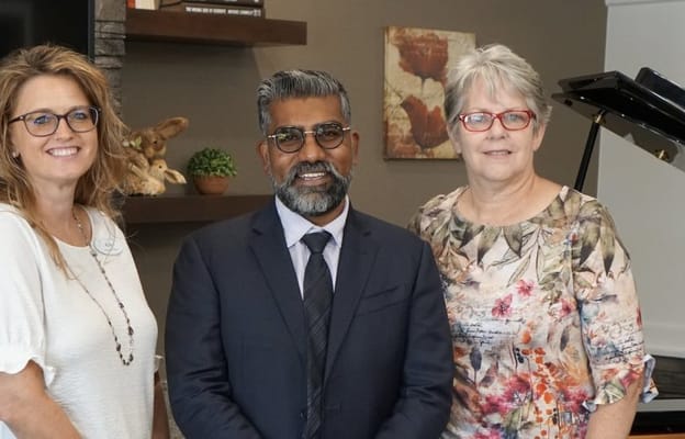 Three staff members posing in a facility common area