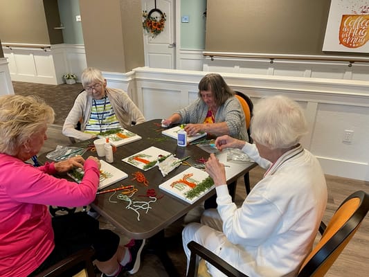 Residents engaged in a craft activity inside the facility