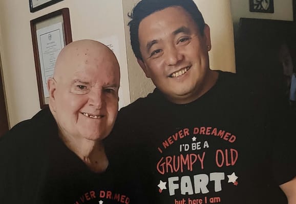 Two residents posing with matching shirts and smiles