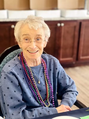 Resident smiling with beads during a celebration