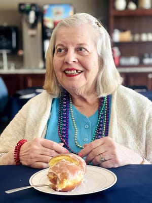 Resident enjoying a donut with festive beads